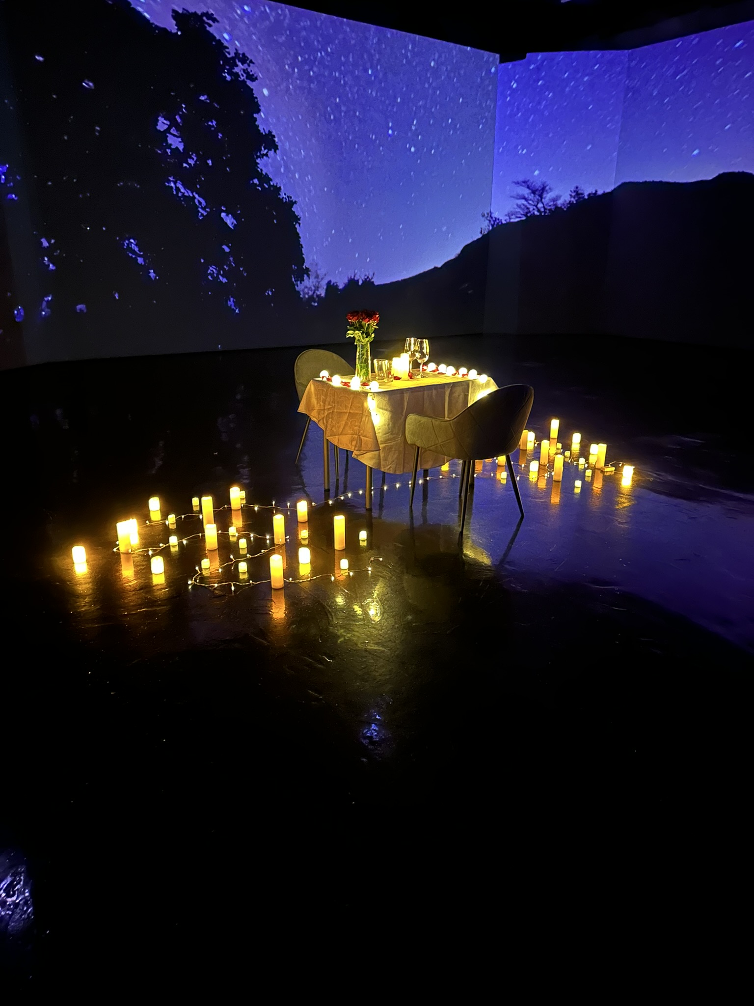Romantic candlelit dinner setup by the lake at night in Budapest - intimate outdoor dining with hundreds of candles